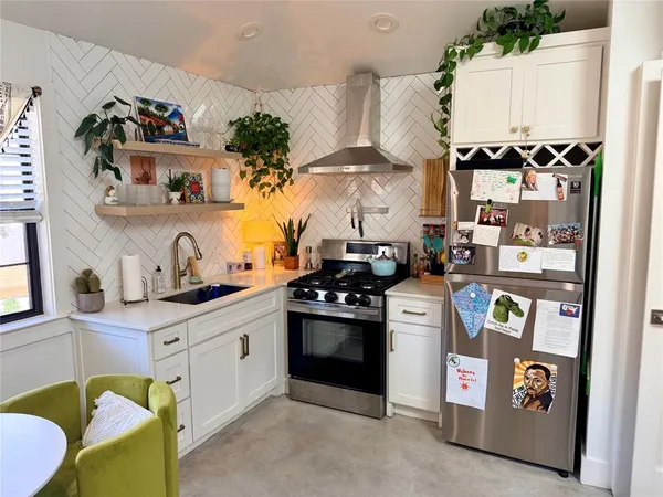 a kitchen with a stove a refrigerator and a clock on the wall