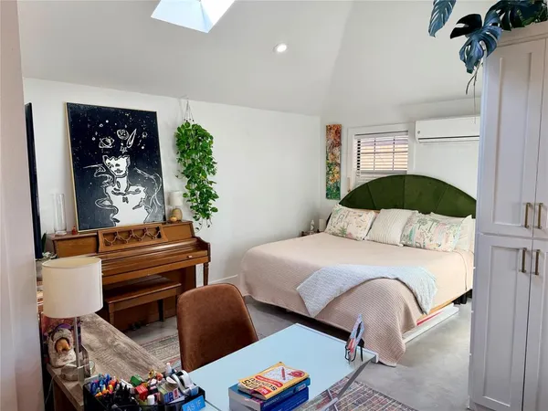 a bedroom with a bed lamp and a potted plant
