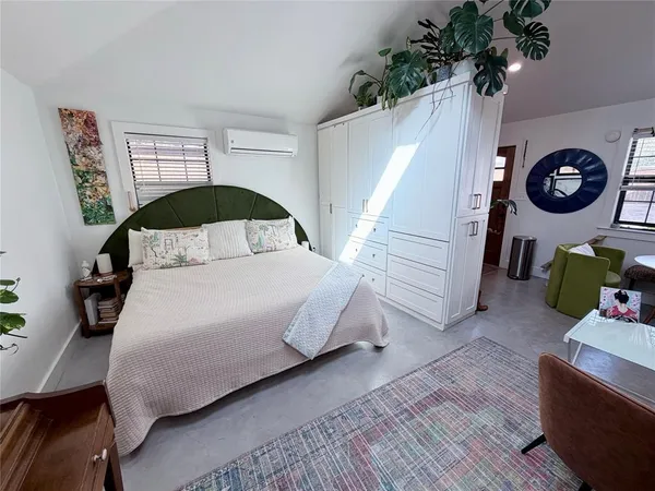 a bedroom with a bed and a potted plant