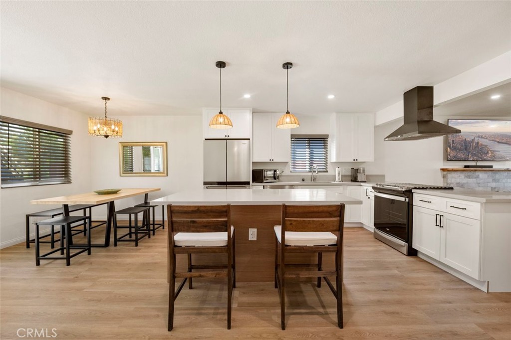 332 Cadillac Circle Oceanside, CA 92054 - Photo 14 of 31 a kitchen with kitchen island granite countertop a sink chairs and white cabinets