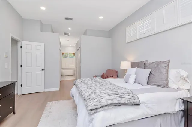 a bedroom with a large bed and a chandelier