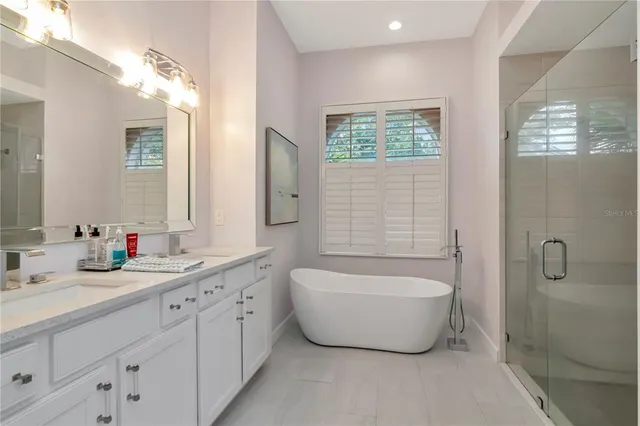 a bathroom with a tub sink and mirror