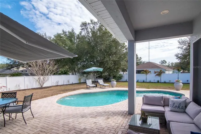 a swimming pool with outdoor seating and yard