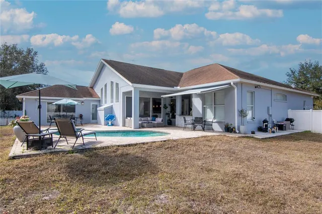a view of a house with backyard porch and sitting area