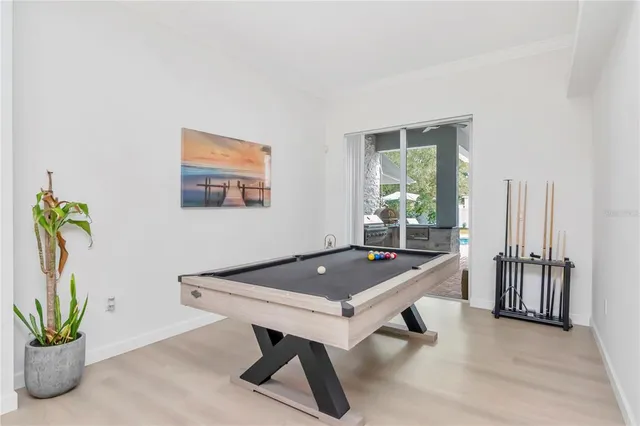 a room with pool table and windows
