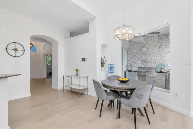 a dining room with furniture a chandelier and wooden floor