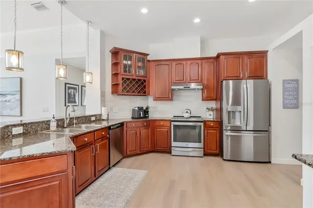 a kitchen with stainless steel appliances granite countertop a refrigerator sink and stove