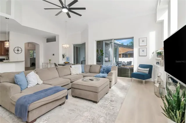 a living room with furniture a flat screen tv and a large window