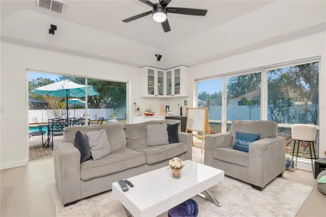 a living room with furniture and a large window with garden view