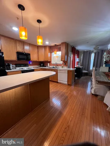 a view of a livingroom with wooden floor and a ceiling fan
