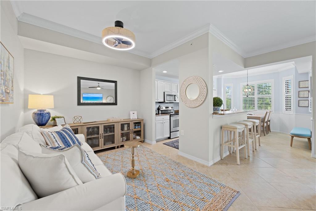 9715 Acqua Court, Unit 116 Naples, FL 34113 - Photo 5 of 43 a living room with furniture and a clock