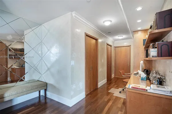 a view of a hallway with bathroom and wooden floor