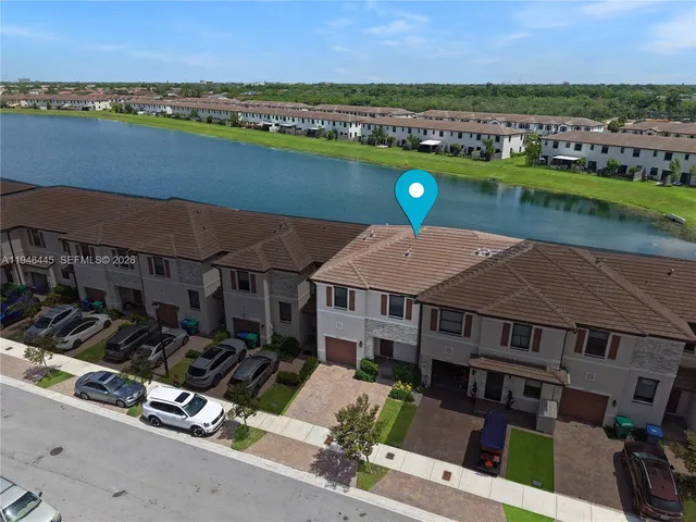 an aerial view of a house with a garden and lake view