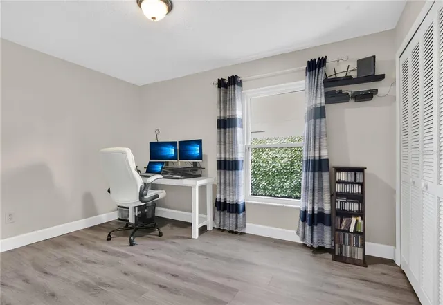 a view of a workspace with furniture and a window
