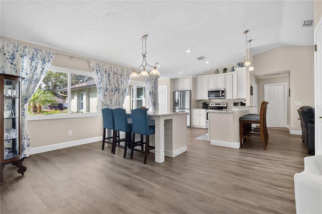 9426 Palm Tree Drive Windermere, FL 34786 - Photo 4 of 29 a open kitchen with stainless steel appliances granite countertop a refrigerator dining table and chairs with wooden floor