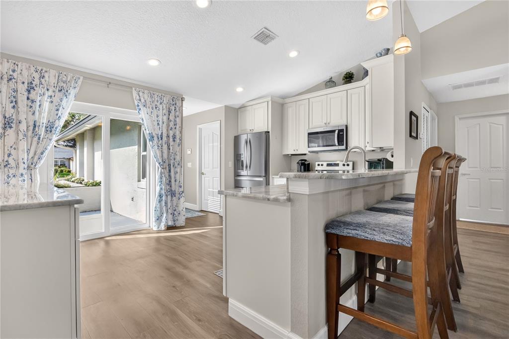 9426 Palm Tree Drive Windermere, FL 34786 - Photo 8 of 29 a kitchen with kitchen island a stove a table and chairs in it
