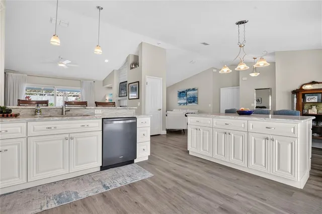 a kitchen with white cabinets and sink