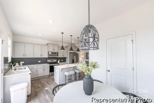 a view of a kitchen with a sink a microwave and cabinets
