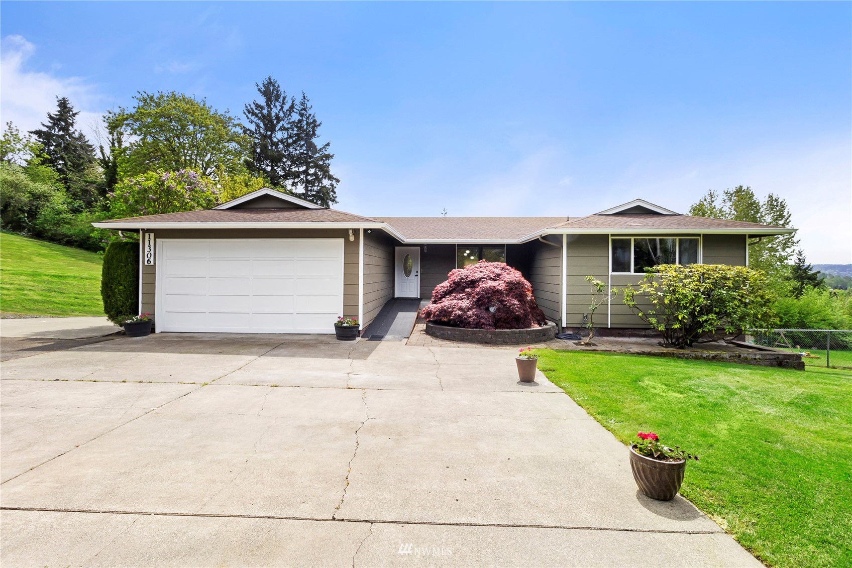 11306 Karshner Road East Edgewood, WA 98372 - Photo 2 of 31 a front view of a house with a yard and garage