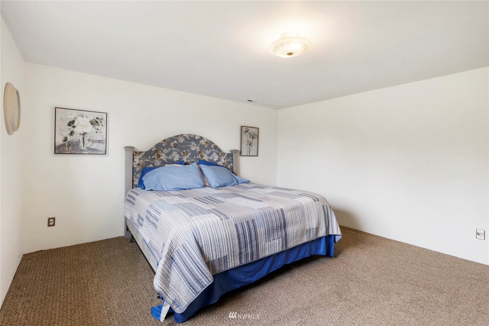 11306 Karshner Road East Edgewood, WA 98372 - Photo 21 of 31 a bedroom with a bed and painting on the wall