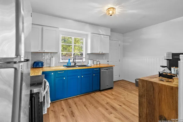 a kitchen with a window wooden cabinets and a sink
