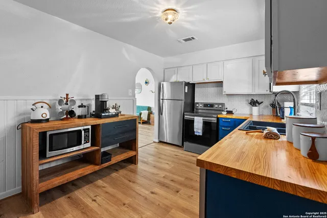 a kitchen with stainless steel appliances kitchen island granite countertop a stove a sink and a refrigerator