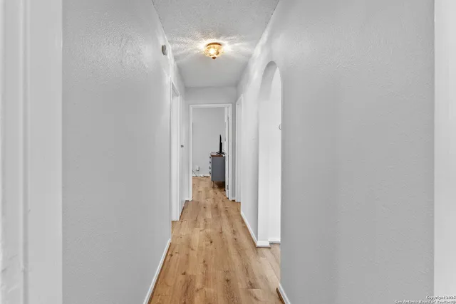 a view of a hallway with wooden floor