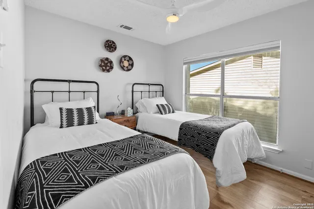 a bedroom with two beds and a large window