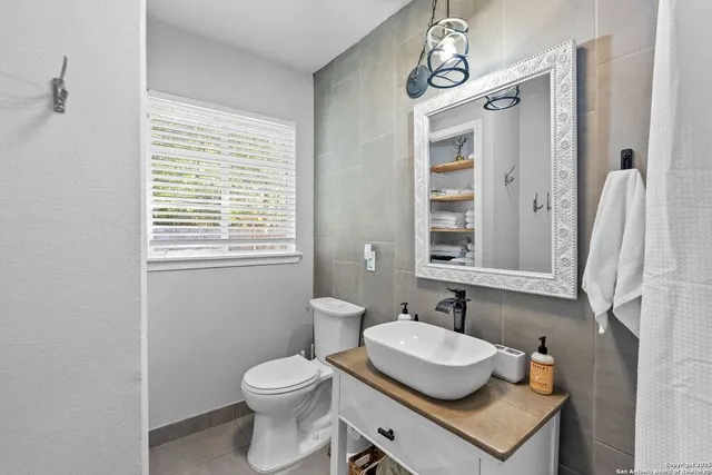 a bathroom with a toilet sink and mirror