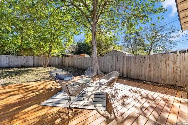 a view of a backyard with a patio and wooden fence