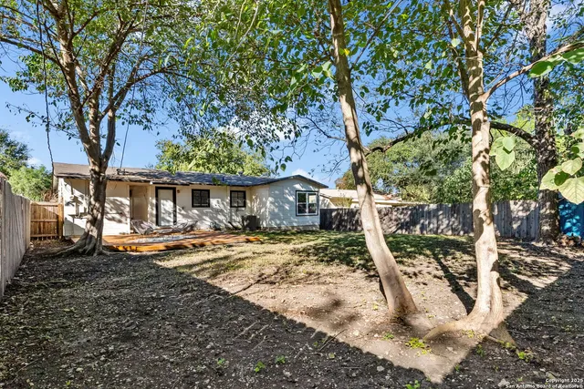 a view of a house with a yard tree and sitting area