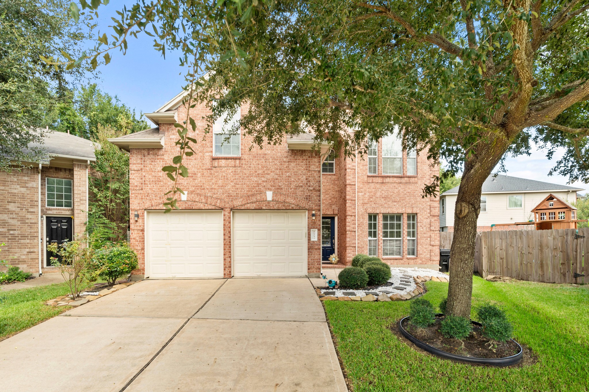 a front view of a house with a yard garage and fountain