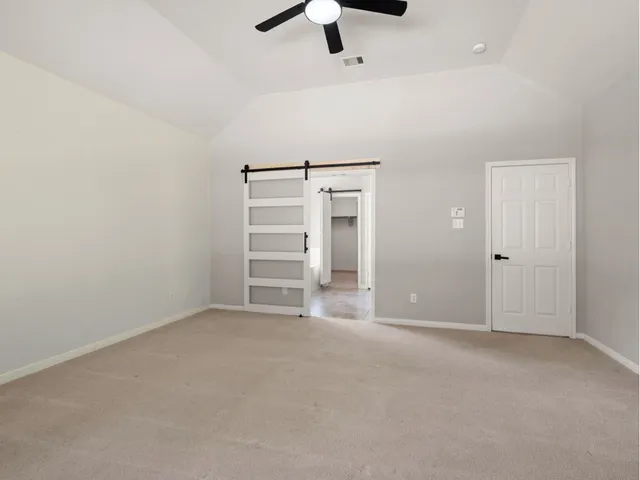an empty room with chandelier fan
