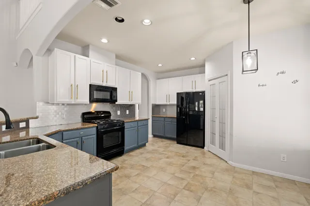 a kitchen with stainless steel appliances granite countertop a refrigerator stove microwave and sink