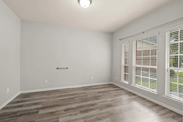 wooden floor in an empty room with a window