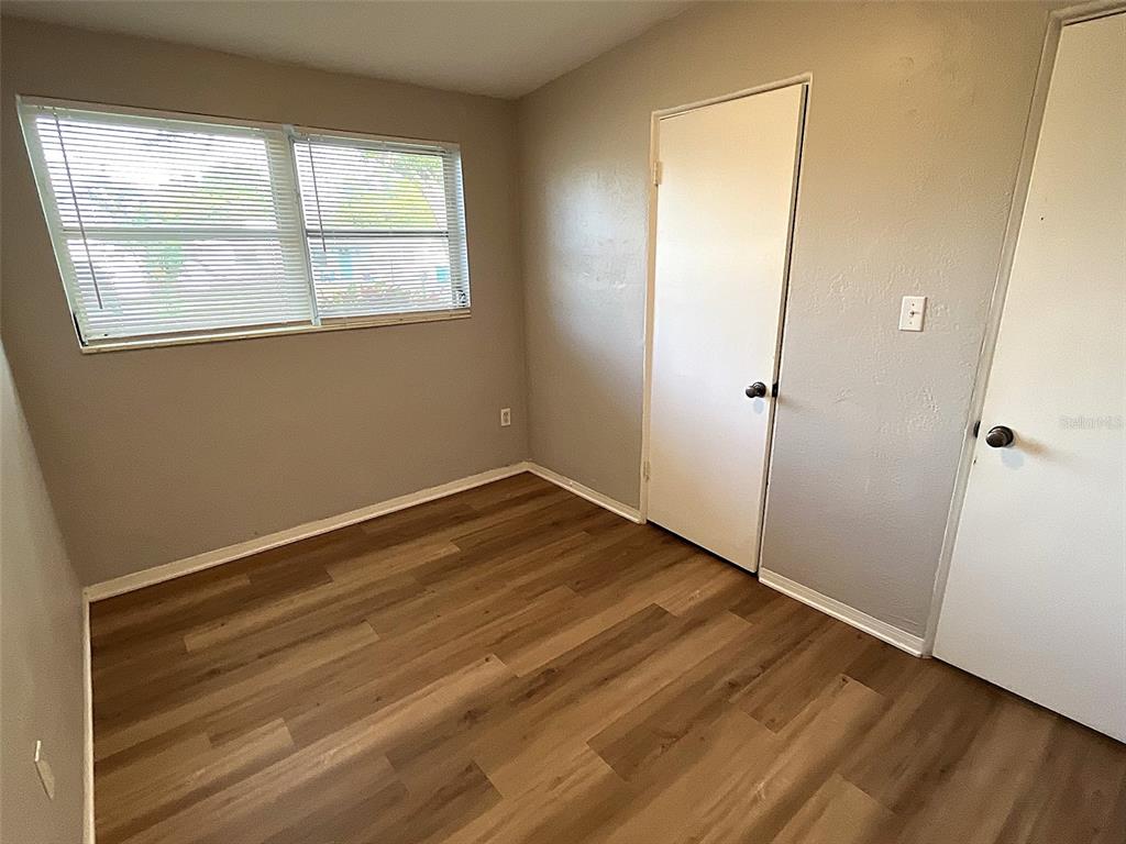 9596 Groveland Street Seminole, FL 33772 - Photo 20 of 26 an empty room with wooden floor and windows