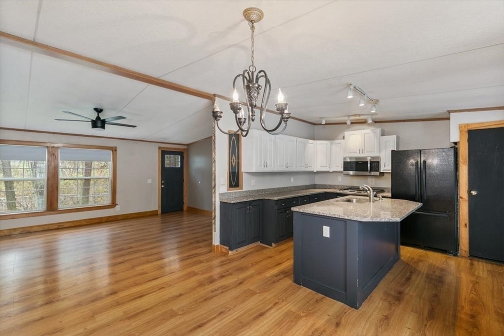 84 Forest Road Salisbury, MA 01952 - Photo 8 of 28 a kitchen with stainless steel appliances granite countertop a sink stove and wooden floor
