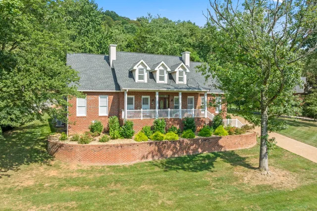 a front view of a house with a porch and a yard