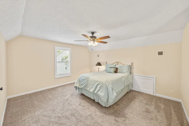 a spacious bedroom with a bed and a chandelier