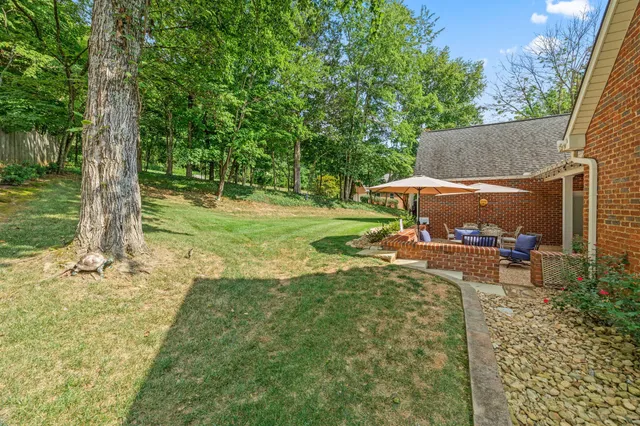 an aerial view of residential houses with outdoor space and trees