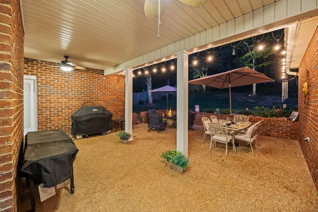 a view of a patio with table and chairs under an umbrella