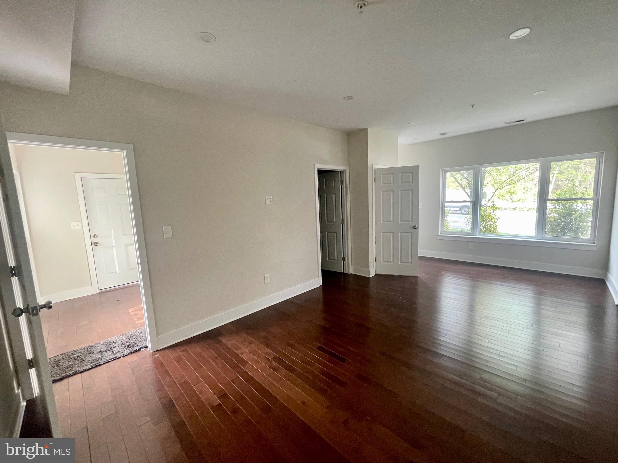 8618 Jones Mill Road Chevy Chase, MD 20815 - Photo 19 of 52 an empty room with wooden floor and windows