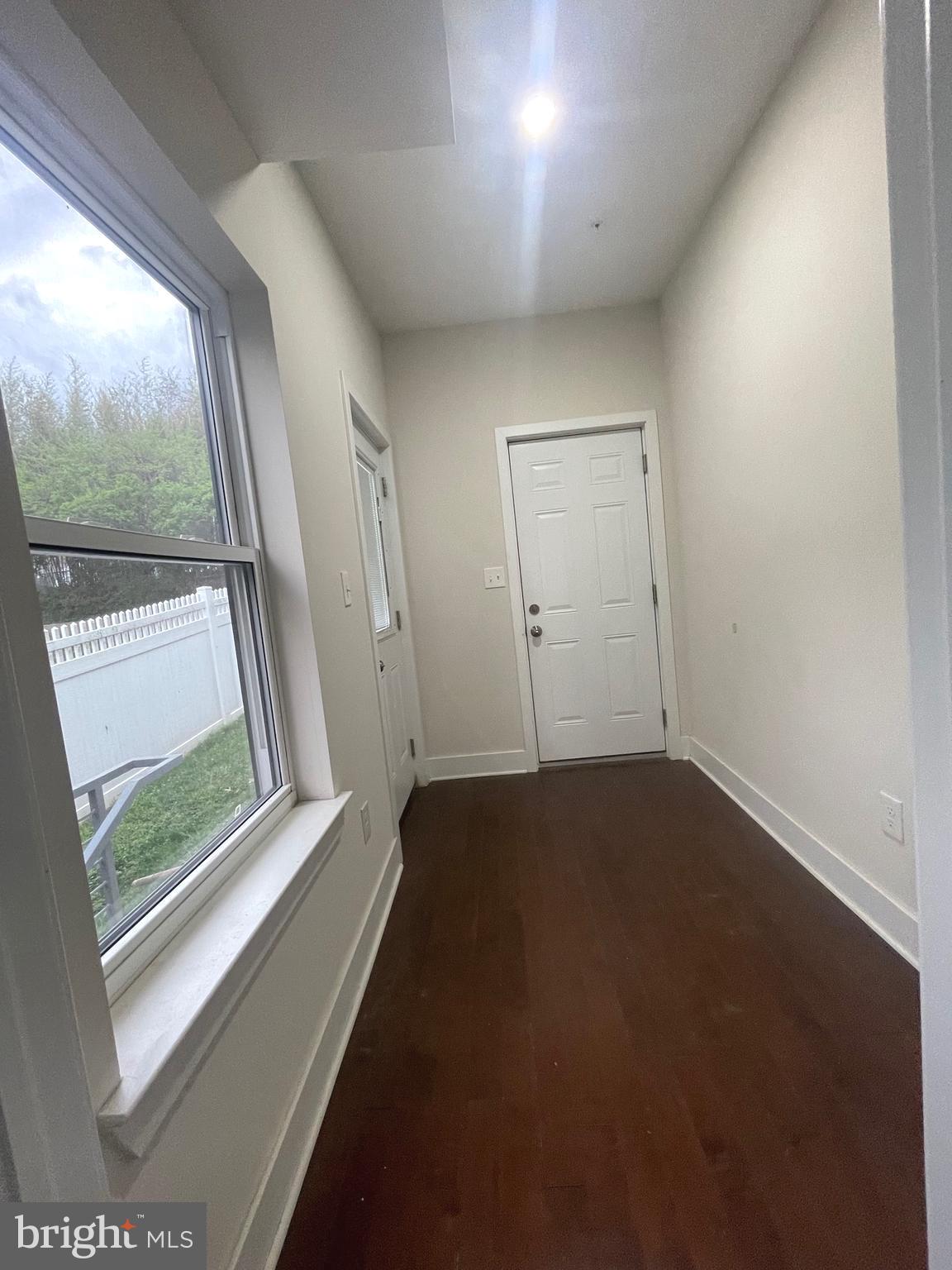 8618 Jones Mill Road Chevy Chase, MD 20815 - Photo 20 of 52 an empty room with wooden floor and windows