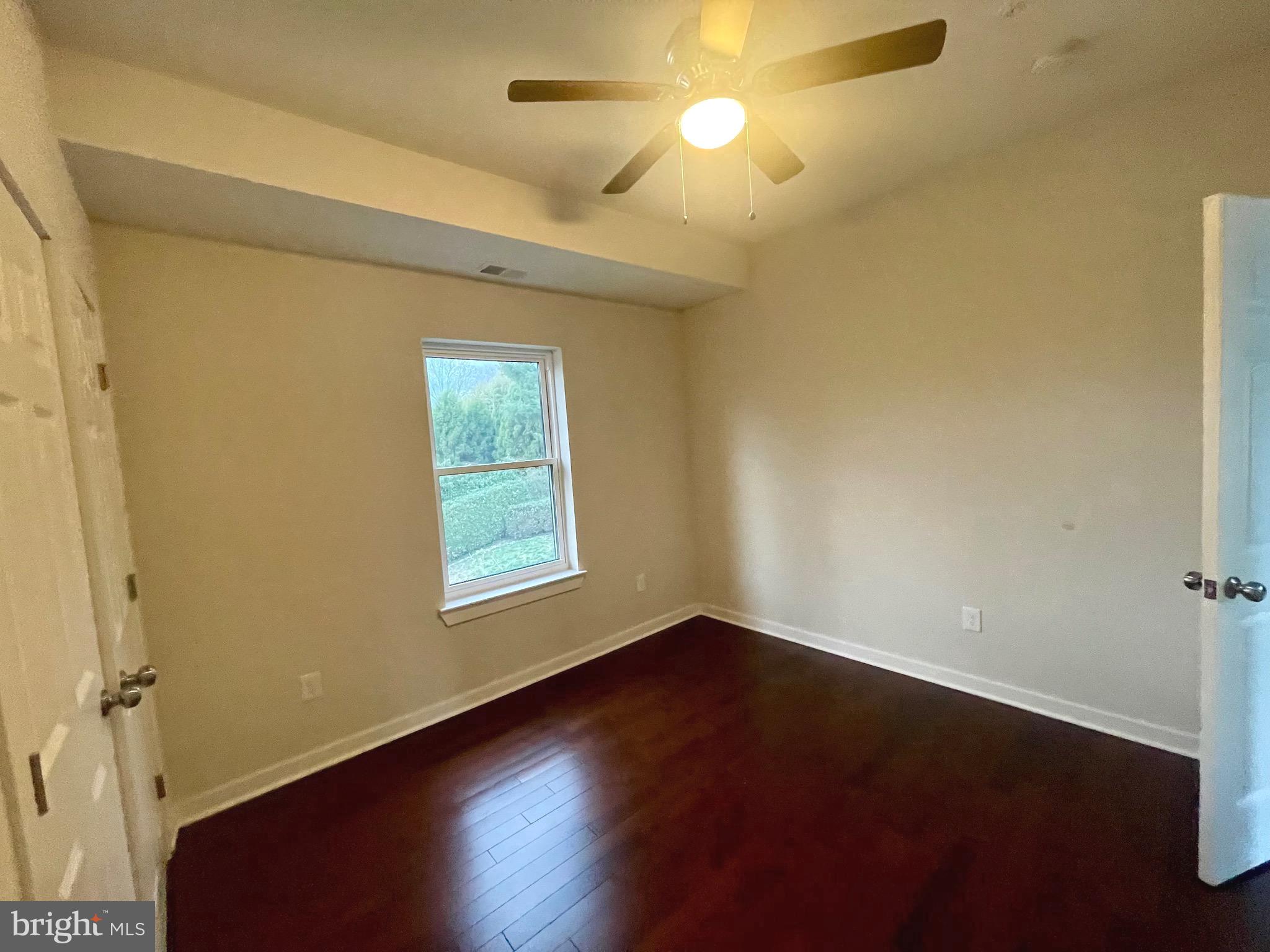 8618 Jones Mill Road Chevy Chase, MD 20815 - Photo 33 of 52 an empty room with wooden floor and windows