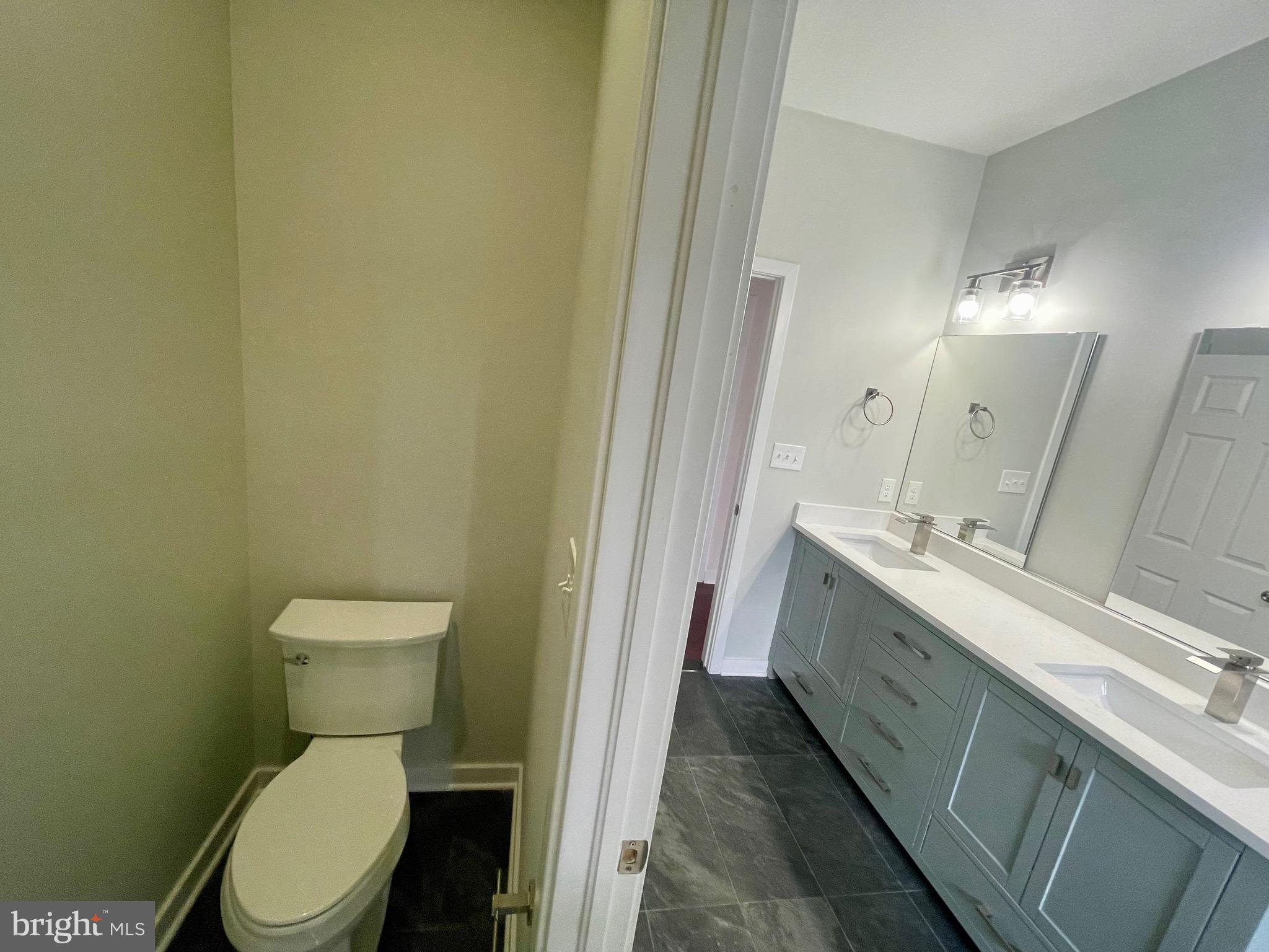 8618 Jones Mill Road Chevy Chase, MD 20815 - Photo 49 of 52 a bathroom with a toilet a sink and mirror