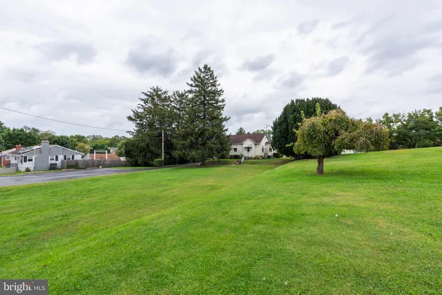 a view of a house with a big yard and palm trees