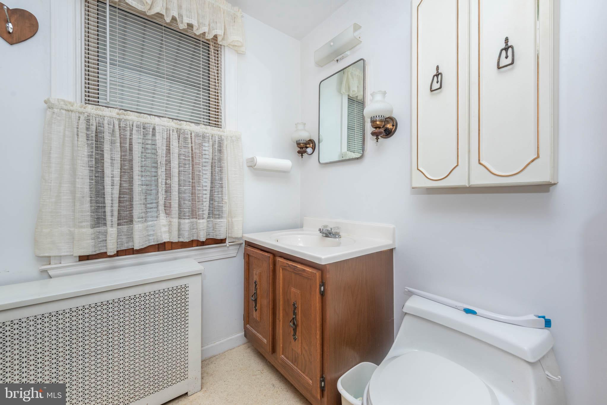 3417 East Joppa Road Baltimore, MD 21234 - Photo 10 of 51 a bathroom with a sink a toilet and a mirror