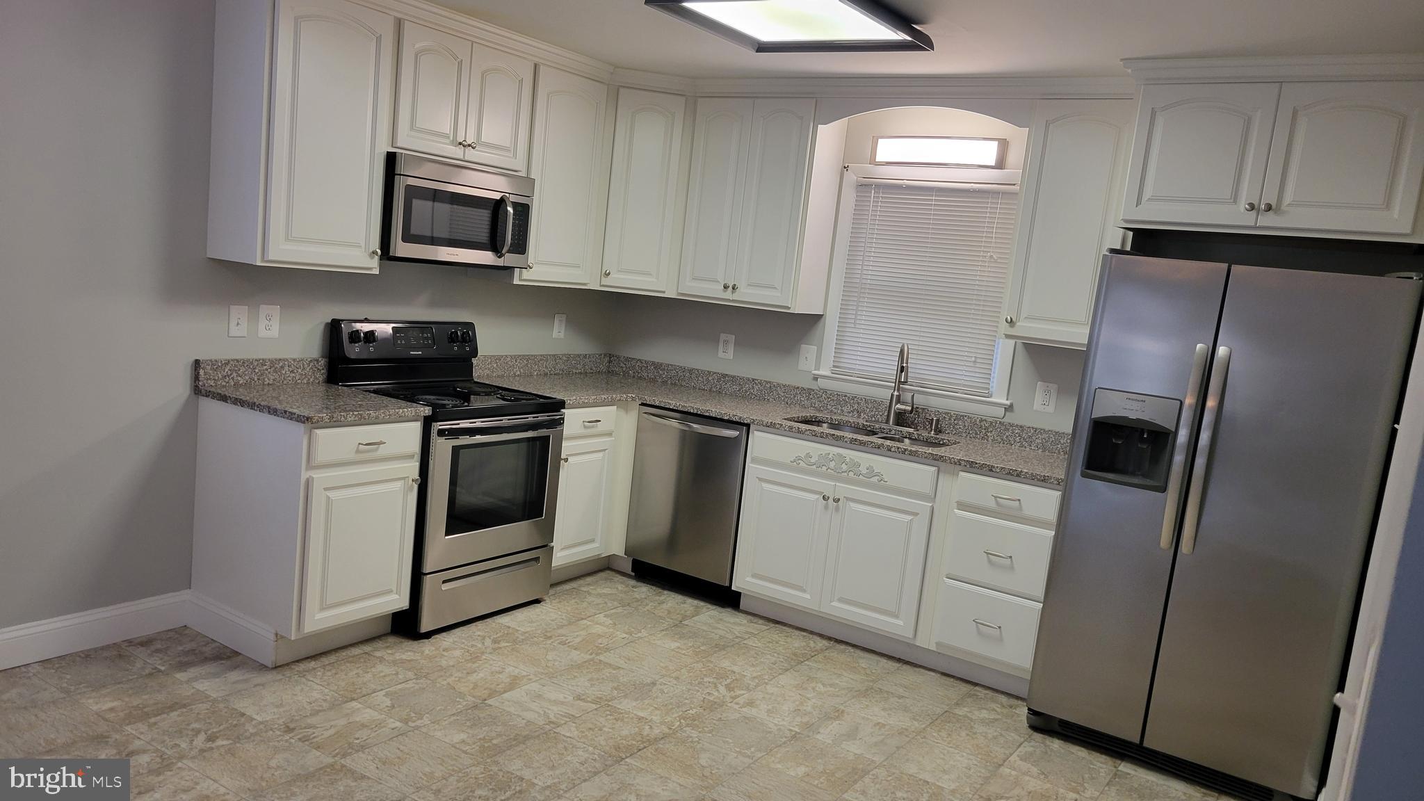 29620 Whalen Road Charlotte Hall, MD 20622 - Photo 6 of 16 a kitchen with white cabinets stainless steel appliances and sink