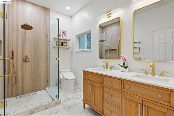 a bathroom with a granite countertop sink a toilet and shower