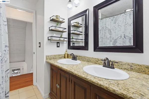 a bathroom with a granite countertop sink and a mirror